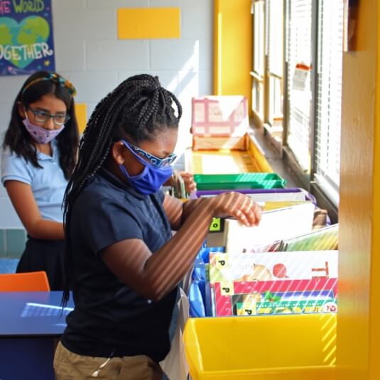 child picking out books in classroom