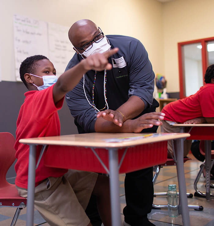 child pointing something out to teacher