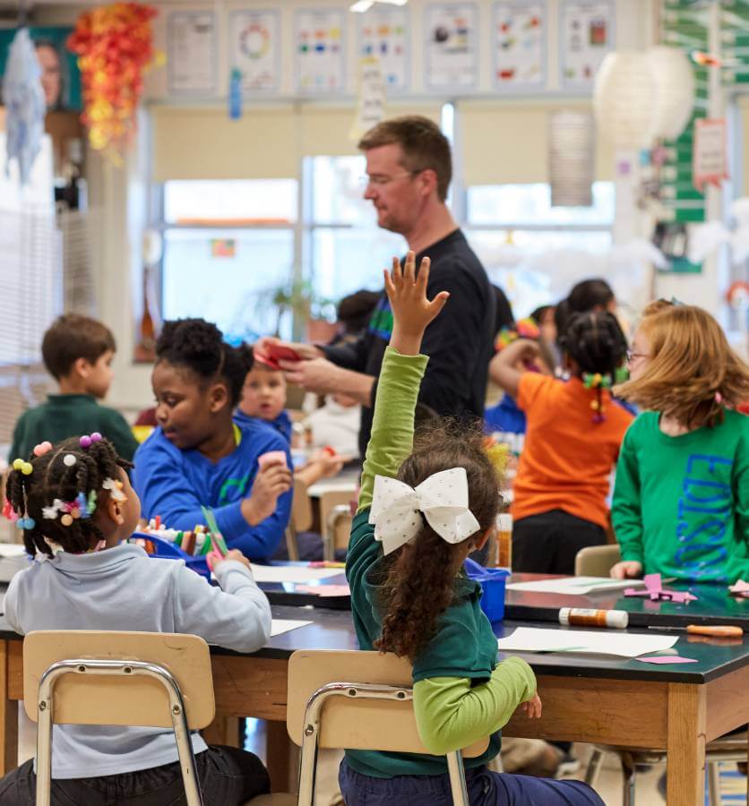 elementary student raising hand in class