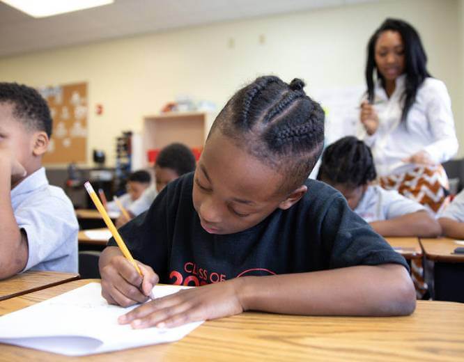 elementary student writing at desk