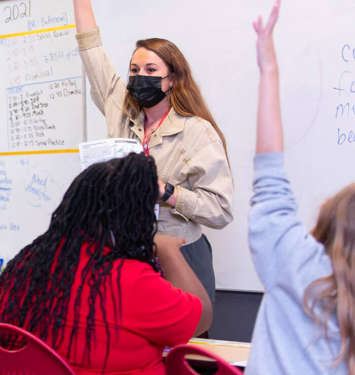 teacher and student with raised hand