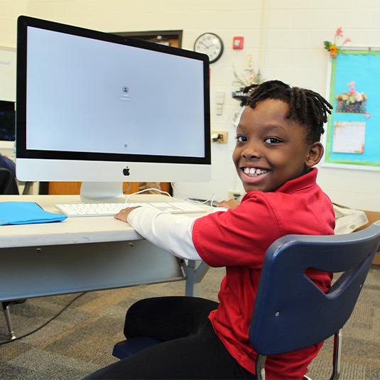 Young boy working on computer.