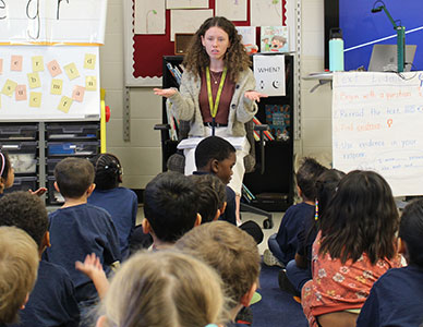 Young female teacher reading to students.