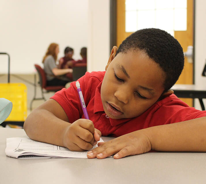 student writing with pencil