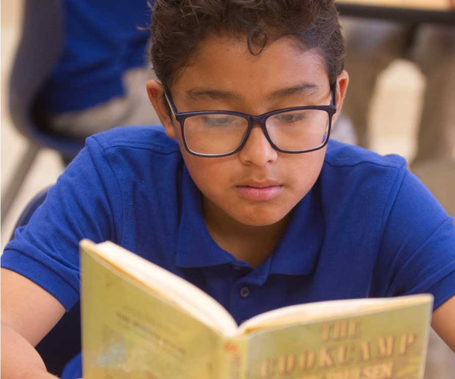 young child reading at desk