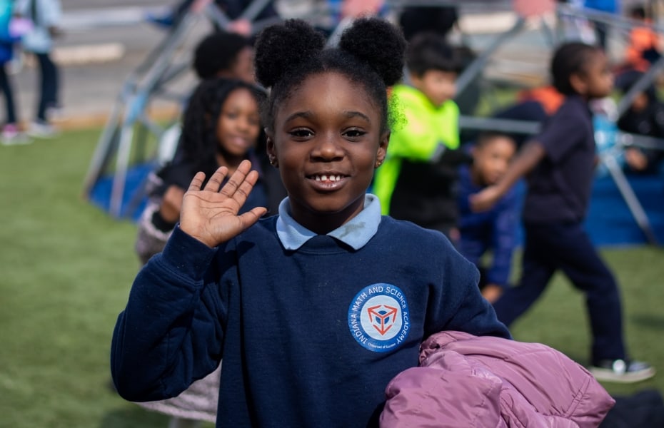 Young girl waving on playground