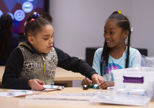 little girls playing at desk together