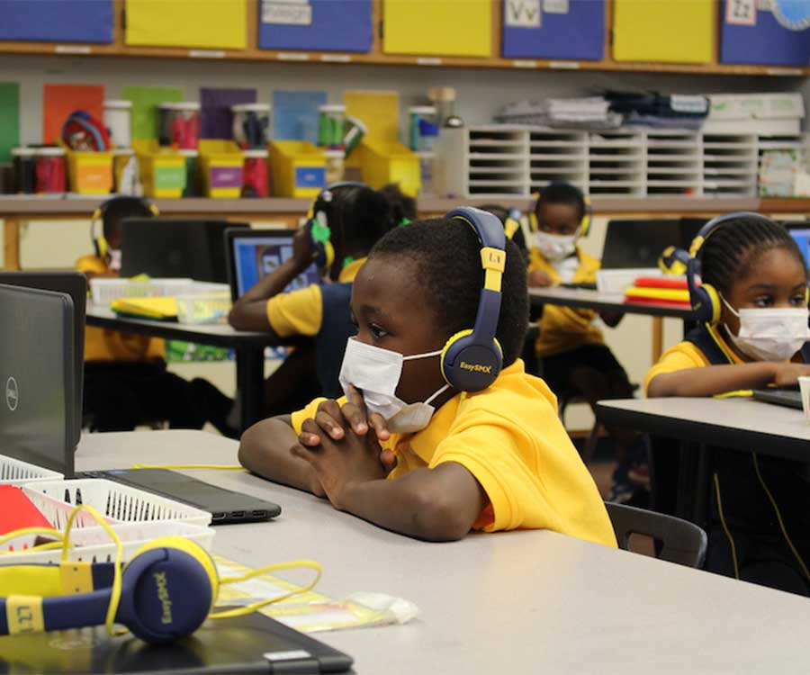 child focusing on computer while sitting at desk