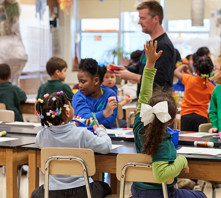 student raising hand in classroom