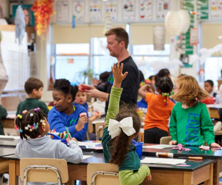 teacher walking around classroom while teaching lesson