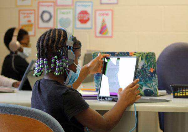 youg child playing on computer with headphones on